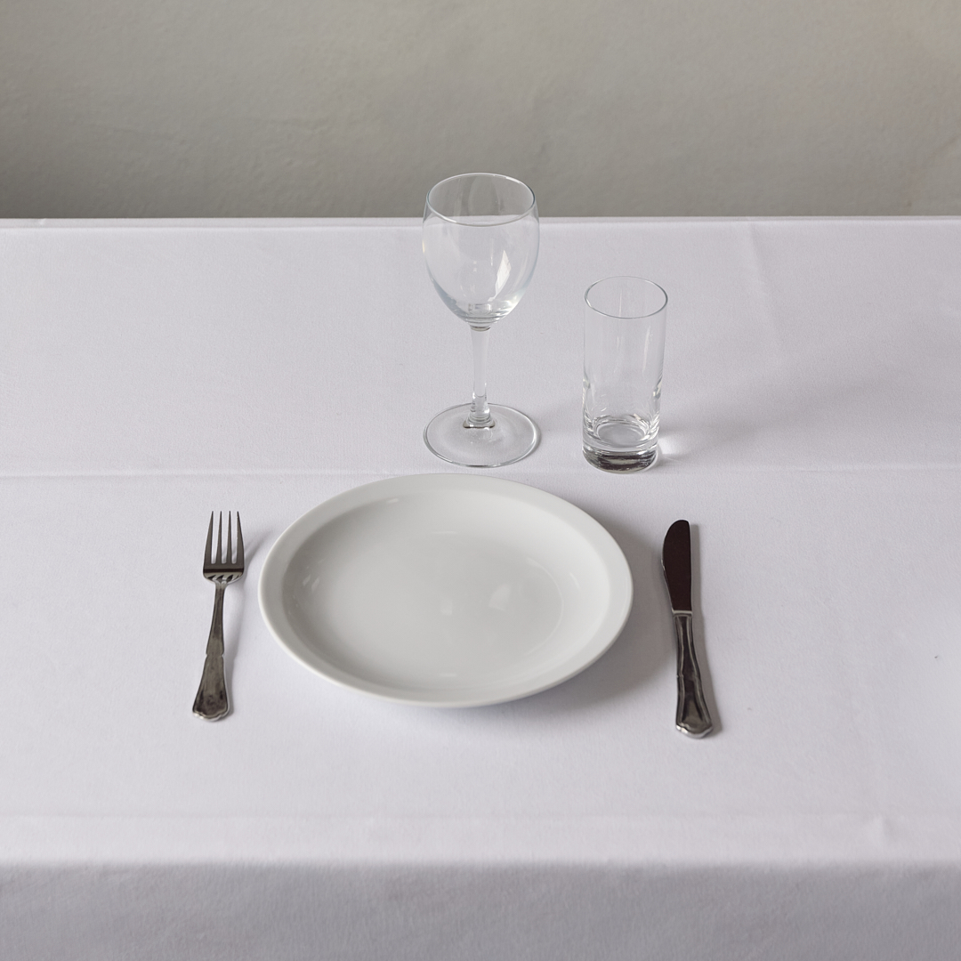 Eight shirts arranged on table in black, olive, grey, blue, white, red, mustard, and green.